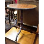A mahogany circular dished topped occasional table raised on turned column to three outswept