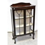 A reproduction mahogany display cabinet with simple arched back above bow front central section