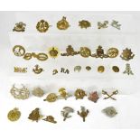 A collection of various military cap badges and shoulder titles to include Royal Artillery, RAF,
