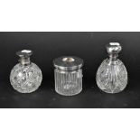 A George V ovoid cut glass perfume bottle with engine turned and fleur-de-lys chased decoration to