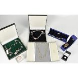 Seven cased sets of costume jewellery, to include a white metal amethyst and blue stone necklace,