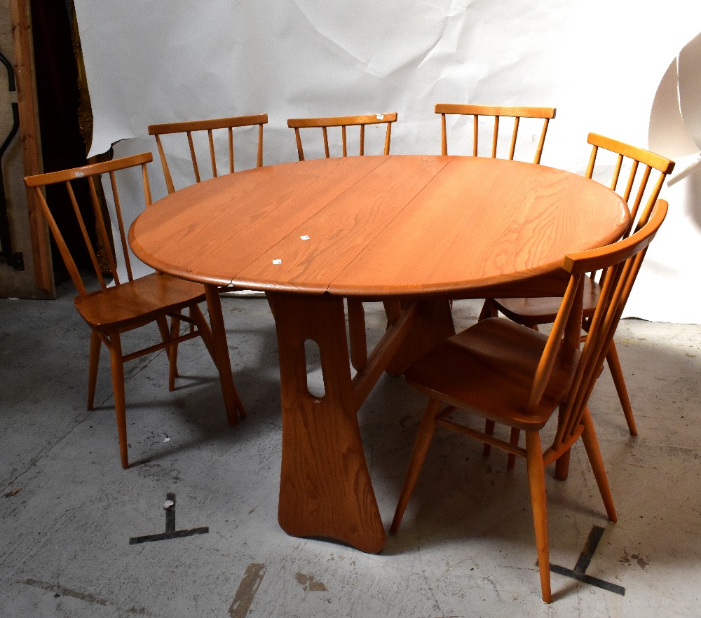 A contemporary pale oak drop-leaf circular dining table to slab supports, length when extended 73.