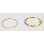 Two yellow metal bangles, one with clasp and safety chain,