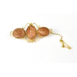 A 15ct yellow gold three-panel goldstone brooch, length approx 5cm, with safety chain, approx 6.2g.