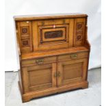 A Victorian oak bureau, the vertical fall front centred with a carved panel,