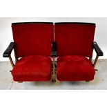 A pair of vintage folding cinema seats, upholstered in red velour with black painted wooden trim,