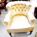 A Victorian walnut framed low button pressed tub chair, with scrolling arms and turned front legs,