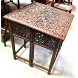 An early 20th century Burmese-style square topped table, the top with carved decoration,