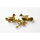 A 9ct gold brooch, two birds on a branch with red stone eyes, length 4cm, approx 4.5g.