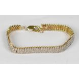 A 9ct yellow gold tennis-style bracelet set with over two hundred white diamonds, approx 19.3g.