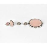 A large rose quartz brooch in scrolling silver frame,