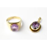 A modern 9ct gold ring with a claw set amethyst in a square mount,