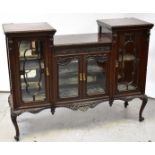 A late 19th/early 20th century dark mahogany display cabinet with central glazed doors flanked by