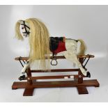 A small model rocking horse with horsehair mane, to wooden and metal base,