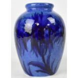 WILLIAM MOORCROFT; a baluster vase, in blue floral pattern on a mottled blue ground, height 18cm.