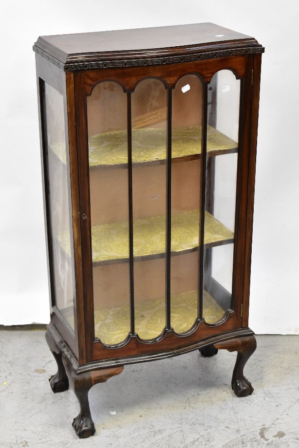 An early 20th century mahogany serpentine front display cabinet with single glazed door,