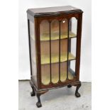 An early 20th century mahogany serpentine front display cabinet with single glazed door,