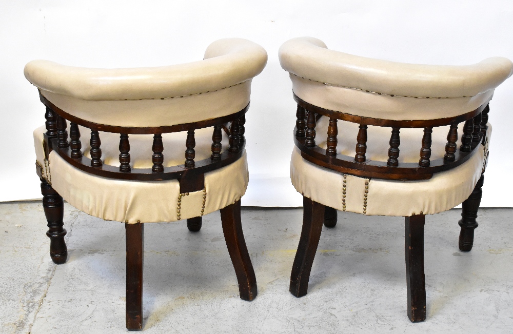 A pair of Victorian walnut framed bow back library chairs upholstered in beige leatherette with