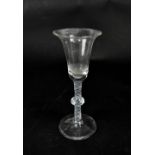 An 18th century wine glass with bell-shaped bowl, multiple opaque twist stem with central knop,