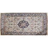 A contemporary cream ground rug with central floral medallion within stepped floral border,
