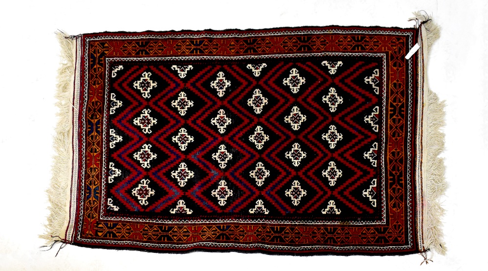 An Afghan Beluch rug with all-over geometric pattern within geometric border, 188 x 110cm.