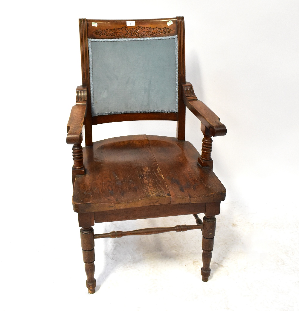 An early 20th century oak open arm elbow chair with saddle seat,