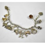 A sterling silver charm bracelet with various silver charms to include a cat in a basket,