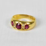 An 18ct gold ring set with three graduated red stones,
