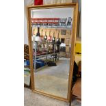 A large contemporary gilded bevel edge wall mirror, 87.5 x 176.5cm.