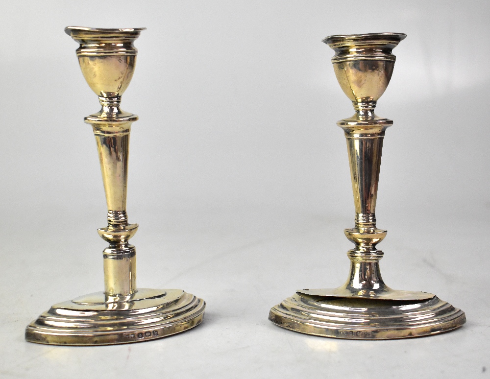 A pair of Edward VII hallmarked silver column candlesticks to elliptical stepped bases,