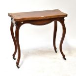 A mahogany serpentine fronted fold-over card table with circular baize lined interior above shaped