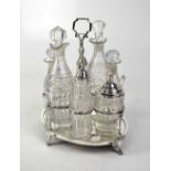 A cut glass condiment set with hallmarked silver lids, marks rubbed, on a silver plated stand.