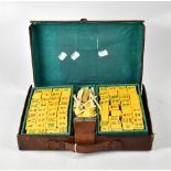 An early 20th century Mah-Jong set contained in a small brown leather case.