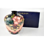 MOORCROFT; a blue-green ground baluster vase with tube lined decoration in the 'Honeysuckle' design,