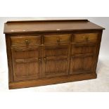 A mid-20th century sideboard, with raised back above three drawers and three panelled doors,