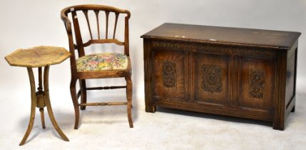 A reproduction oak three-panel coffer, the hinged lid above carved frieze,