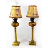 A pair of Victorian brass oil lamps with amber wrythen glass reservoirs, with 20th century shades,