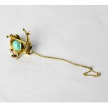 A yellow metal brooch in the form of a chick on skis, with ski poles,