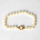 A cultured pearl bracelet with a 9ct yellow gold clasp set with single pearl and two small rubies.
