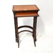 An early 20th century mahogany nest of three tables to faux bamboo supports and curved