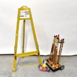 A mid-20th century wooden croquet set, on a stand, together with a painted wooden easel,