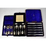 A cased set of hallmarked silver handled butter knives with seal end finials,