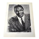 NAT KING COLE; a torn page with a black and white photograph, bearing his signature, 27 x 21cm.