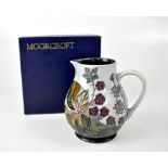 MOORCROFT; a pale grey-blue drip glaze ground jug with tube lined 'Bramble' design,