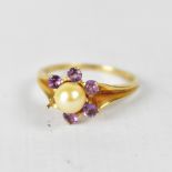 A 9ct gold dress ring set with central pearl surrounded by amethysts in a flowerhead setting (one