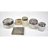 Three vintage cut glass vanity bottles with hallmarked silver tops,