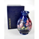 MOORCROFT; a cobalt blue ground baluster vase with tube lined 'Anemone' decoration, height 19cm,