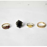 A yellow metal ring set with red stones and seed pearls (af, two seed pearls missing),
