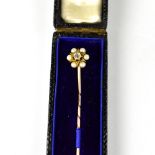 A Victorian tiepin set with diamond and seed pearl cluster, on yellow metal pin, length 6.4cm.