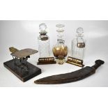 A collectors' lot comprising three cut glass decanters with silver decanter labels,